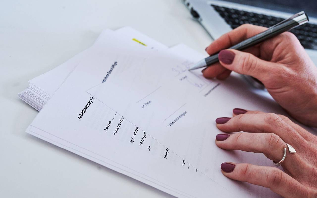 Frau unterschreibt einen Arbeitsvertrag