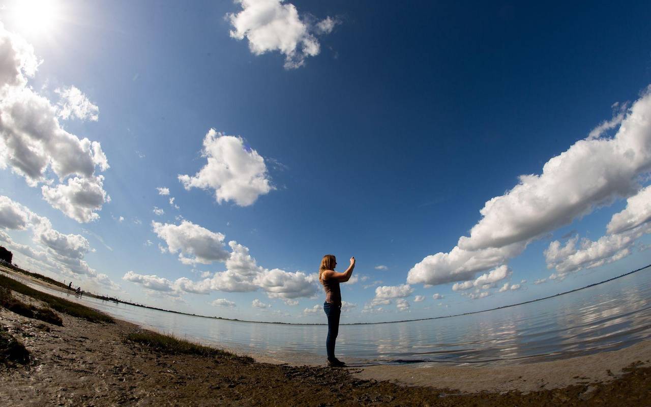 Frau fotografiert mit einem Smartphone die Landschaft