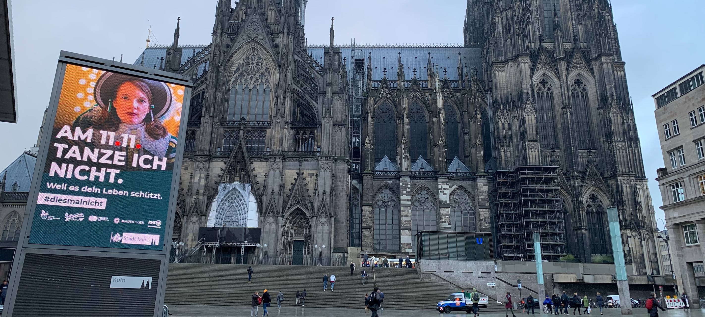 Ein Plakat der Kampagne "#diesmalnicht" hängt groß am Kölner Dom aus.