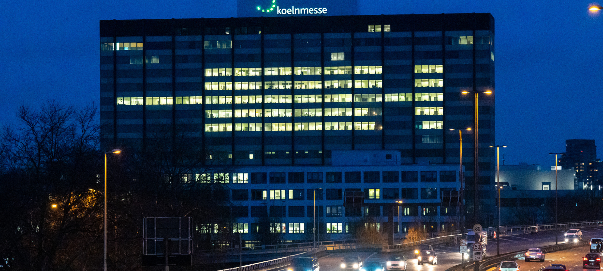 Leuchtende Impfspritze am Messehochhaus